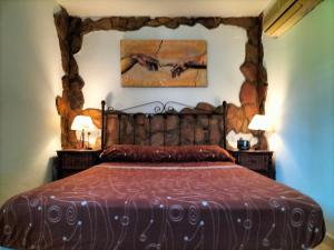 a bedroom with a large bed with a wooden headboard at FINCA RIODIEL in Gibraleón