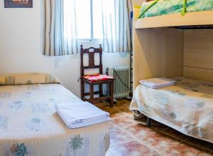 Un dormitorio con dos camas y una silla. en Apartamento Félix Romero II, en Castril