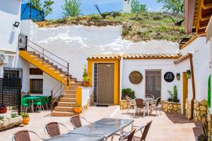 un patio con mesas y sillas frente a una casa en Apartamento Félix Romero II, en Castril