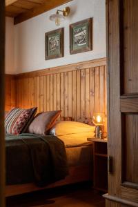 sypialnia z łóżkiem w pokoju z drewnianymi ścianami w obiekcie Willa Staszelówka w Zakopanem