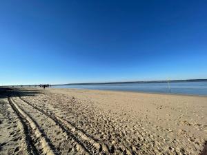 a beach with footprints in the sand and the water at Studio Duplex Arcachon in Arcachon