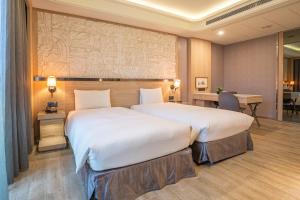 Rúm í herbergi á Guide Hotel Taichung Ziyou