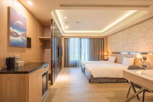 Rúm í herbergi á Guide Hotel Taichung Ziyou