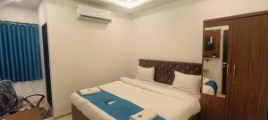 a bedroom with a large bed with a blue blanket at WELCOME VISTA in Navi Mumbai