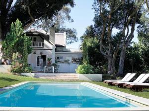 a swimming pool in front of a house at Kloofzicht Estate Country House in Tulbagh