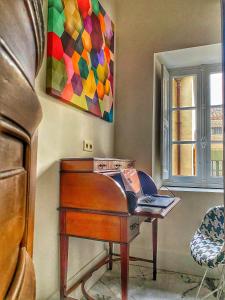 a piano in a room with a painting on the wall at CARCASSONNE HISTORIC DUPLEX 4 star air conditioned APARTEMENT d`ÉGLANTINE in Carcassonne