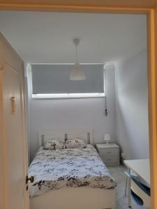 a small bedroom with a bed with a window at K House in Odivelas