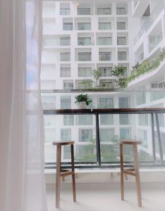 Apec mandala new Phú yên في توي هوا: شرفة مع اثنين من الكراسي الخشبية أمام المبنى