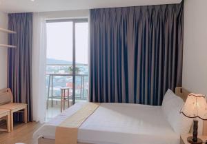 Habitación de hotel con cama y balcón en Apec mandala new Phú yên, en Tuy Hoa