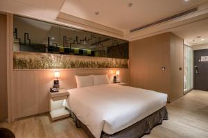 Rúm í herbergi á Guide Hotel Taichung Ziyou