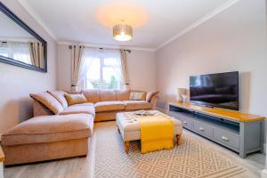 a living room with a couch and a flat screen tv at Country View Cottage in Halvergate