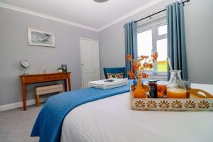 a bedroom with a bed with a table and a window at Country View Cottage in Halvergate