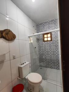 a small bathroom with a toilet and a shower at Casa com Encanto in Pão de Açúcar