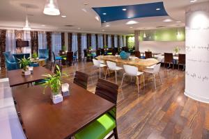 un restaurante con mesas y sillas de madera y un comedor en Holiday Inn Express Indianapolis - Fishers, an IHG Hotel, en Fishers