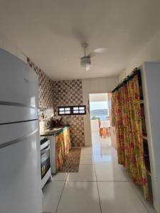 a kitchen with a refrigerator and a table in it at Casa com Encanto in Pão de Açúcar