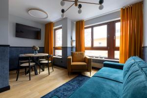a living room with a blue couch and a table at Homewell Apartments Czartoria- free parking in Poznań