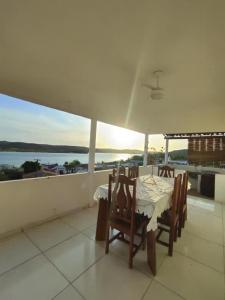 a table and chairs on a balcony with a view of the water at Casa com Encanto in Pão de Açúcar