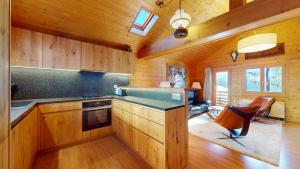 a kitchen with wooden cabinets and a stove at Family chalet in the heart of the Val d'Anniviers in Saint-Luc