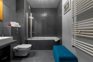 a bathroom with a toilet and a tub and a sink at Homewell Apartments Czartoria- free parking in Poznań