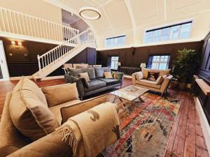 a large living room with couches and a staircase at Pass the Keys Unique town centre apartment with vaulted ceiling in Shrewsbury