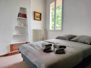 a bedroom with a bed with two towels on it at Superbe T3 avec terrasse en plein cœur du centre historique in Aix-en-Provence