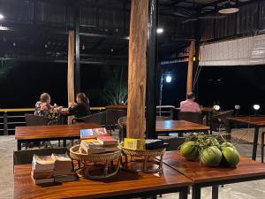 een groep mensen die aan tafel zitten in een restaurant bij Naroth Beach Bungalow in Koh Rong Island