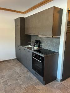 a kitchen with a sink and a stove at Alpen-Apart in Schwendau +36 photos