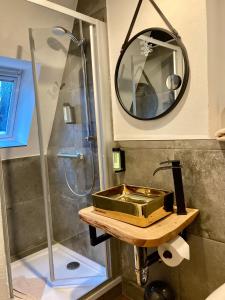 uma casa de banho com um chuveiro, um lavatório e um espelho. em Agli Hotel em Norden