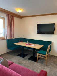 einen Konferenzraum mit einem Tisch und einem TV in der Unterkunft Alpen-Apart in Schwendau