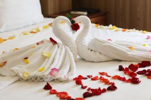 twee zwanen gewikkeld in handdoeken op een bed bij Khách sạn Nắng Biển - Sunny Sea in Nha Trang