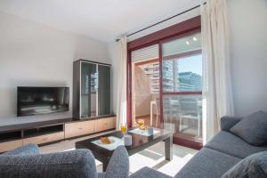 a living room with a couch and a tv at Apartamento Coral Beach - PlusHolidays in Calpe