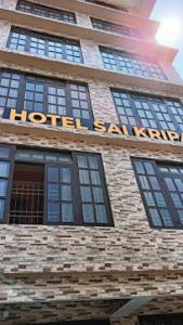 een hotelbord aan de zijkant van een bakstenen gebouw bij Hotel Sai Kripa , Ravangla in Ravangla