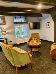 a living room with chairs and a table and a tv at Agli Hotel in Norden