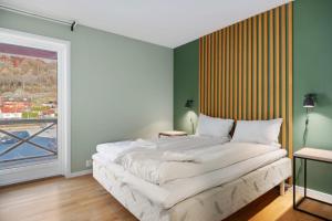 a bedroom with a bed and a large window at Flåm Station Apartments in Flåm