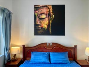 1 dormitorio con 1 cama con una pintura en la pared en Lotus Haven Villa en Siem Riep