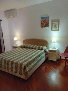 ローマにあるFlavia Apartmentのベッドルーム1室(ベッド1台、テーブル2台、ランプ2つ付)