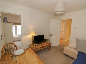 a living room with a table and a television at 7A Lansdown Place Lane in Cheltenham