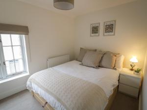 białe łóżko w pokoju z oknem w obiekcie 7A Lansdown Place Lane w mieście Cheltenham