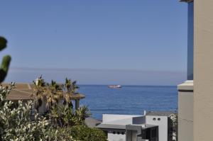 un barco en el océano con un edificio en BellMatt - Table Mountain and Ocean View Guests Suites, en Ciudad del Cabo
