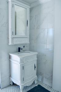 Baño blanco con lavabo y espejo en BellMatt - Table Mountain and Ocean View Guests Suites, en Ciudad del Cabo