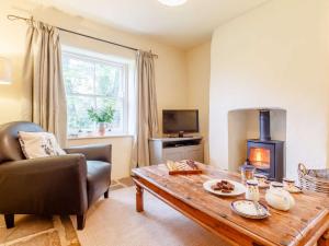 a living room with a wooden table and a wood stove at 2 Bed in Chepstow 42837 in Wolves Newton