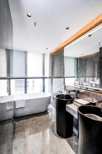 łazienka z wanną i dużym lustrem w obiekcie Yunmu Hotel Luzhou w Luzhou