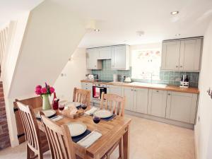 uma cozinha com uma mesa de madeira e cadeiras em 2 Bed in Abergavenny 42909 em Mamhilad