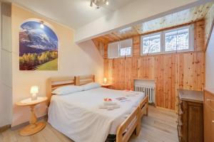 a bedroom with a bed in a room with wooden walls at La Tana Dell'Ermellino 3 Ski In Ski Out - Happy Rentals in Sestriere