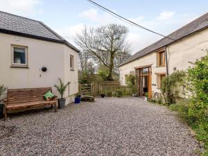 a gravel driveway in front of a house with a bench at 2 Bed in Bude 43239 in Pancrasweek