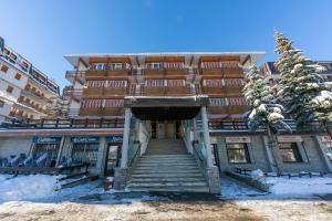 a building with stairs in front of it in the snow at La Tana Dell'Ermellino 3 Ski In Ski Out - Happy Rentals in Sestriere