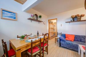 a living room with a table and a blue couch at La Tana Dell'Ermellino 3 Ski In Ski Out - Happy Rentals in Sestriere