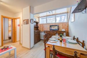 a dining room with a table and a television at La Tana Dell'Ermellino 3 Ski In Ski Out - Happy Rentals in Sestriere