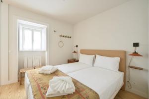 - une chambre blanche avec un lit et une fenêtre dans l'établissement Lisbon All The Best - Bairro Alto 1, à Lisbonne