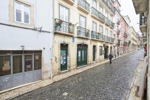 une personne marchant dans une rue pavée avec des bâtiments dans l'établissement Lisbon All The Best - Bairro Alto 1, à Lisbonne